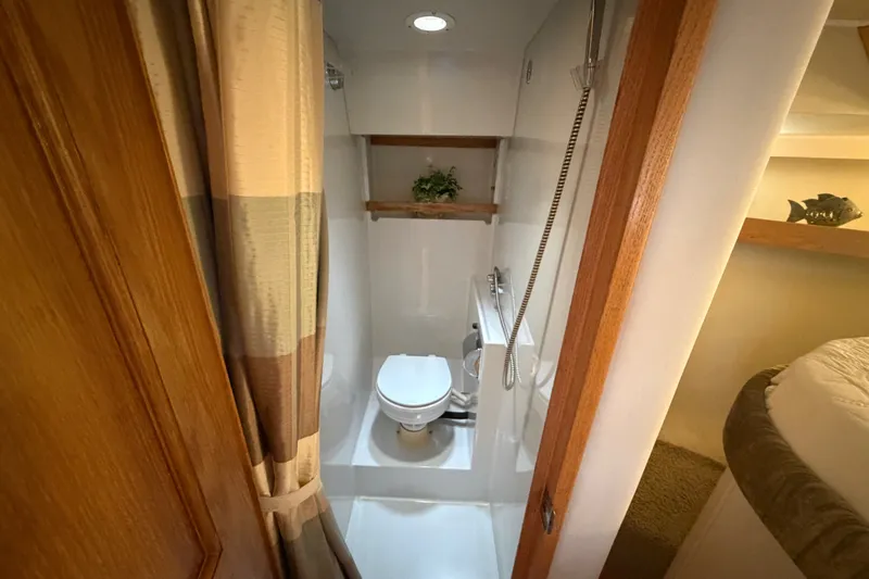 Slide: The Image of 1989 Chris-Craft 427 Catalina bathroom with shower, wooden accents, and decorative plant. - 45