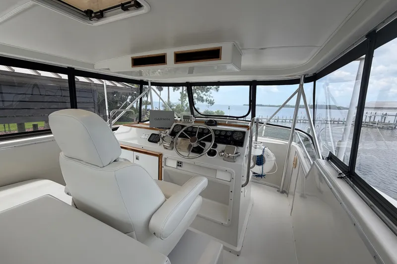 Slide: The Image of Interior of 1989 Chris-Craft 427 Catalina yacht with helm, white seating, and panoramic windows. - 15