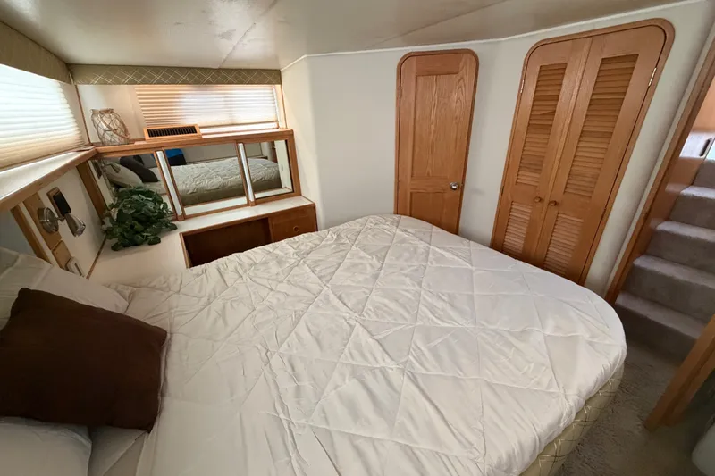 Slide: The Image of Cozy bedroom interior of 1989 Chris-Craft 427 Catalina yacht with wooden accents and plush bedding. - 58