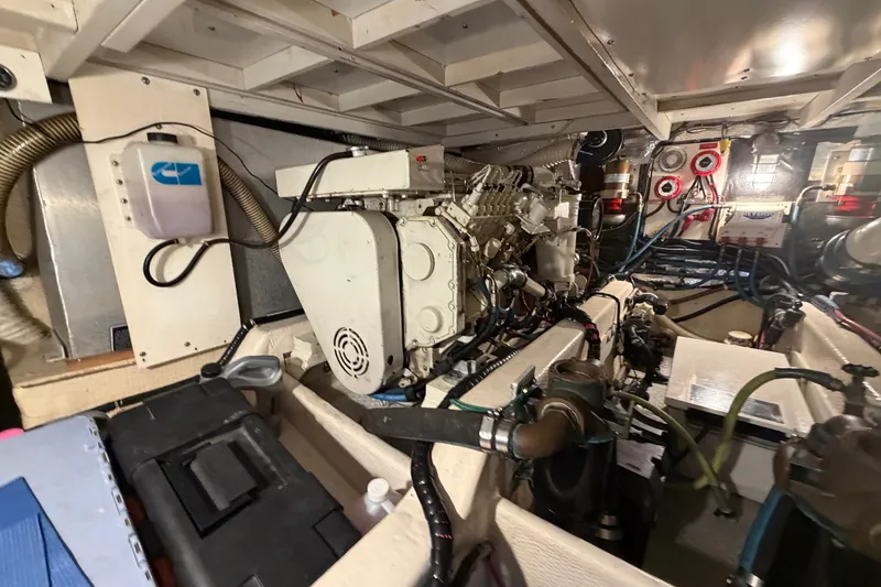 Slide: The Image of Engine room of 1989 Chris-Craft 427 Catalina, showcasing mechanical components and wiring. - 47