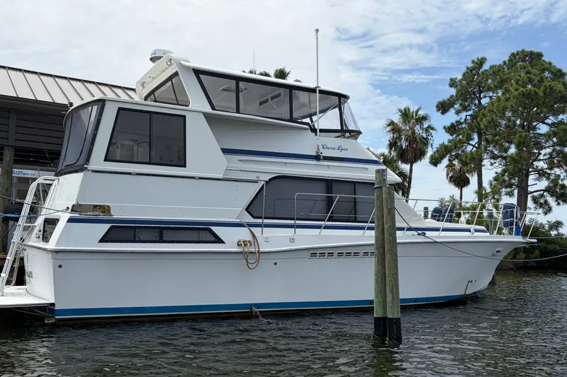 Slide: The Image of 1989 Chris-Craft 427 Catalina yacht docked by palm trees, showcasing sleek design. - 3