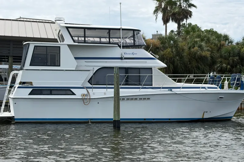 Slide: The Image of 1989 Chris-Craft 427 Catalina yacht docked near palm trees. - 1