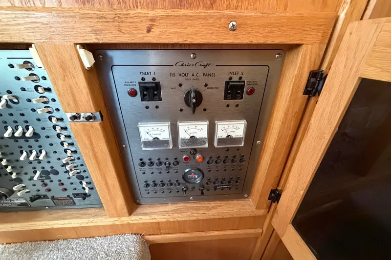 Slide: The Image of 1989 Chris-Craft 427 Catalina electrical panel with gauges and switches in wooden cabinet. - 54