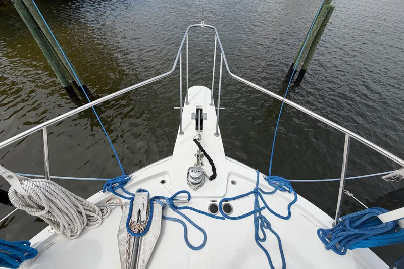 Slide: The Image of Bow view of 1989 Chris-Craft 427 Catalina with ropes and anchor, docked on calm water. - 9