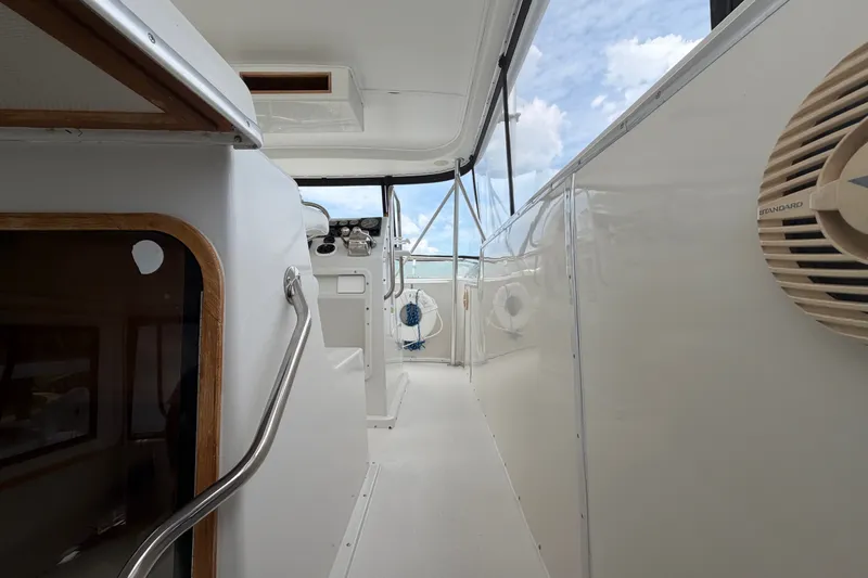 Slide: The Image of 1989 Chris-Craft 427 Catalina yacht interior with helm, white walls, and blue sky view. - 14