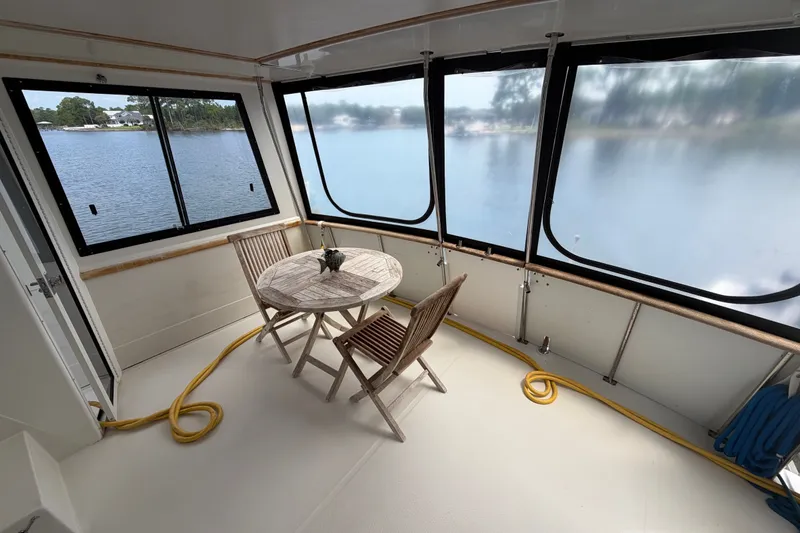 Slide: The Image of 1989 Chris-Craft 427 Catalina interior with table, chairs, and lake view through windows. - 13