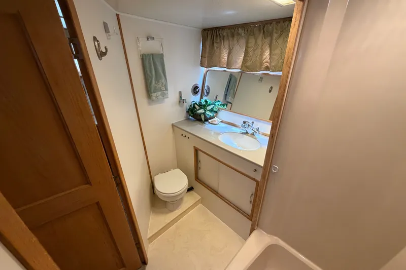 Slide: The Image of Bathroom interior of 1989 Chris-Craft 427 Catalina yacht, featuring sink, toilet, and mirror. - 61