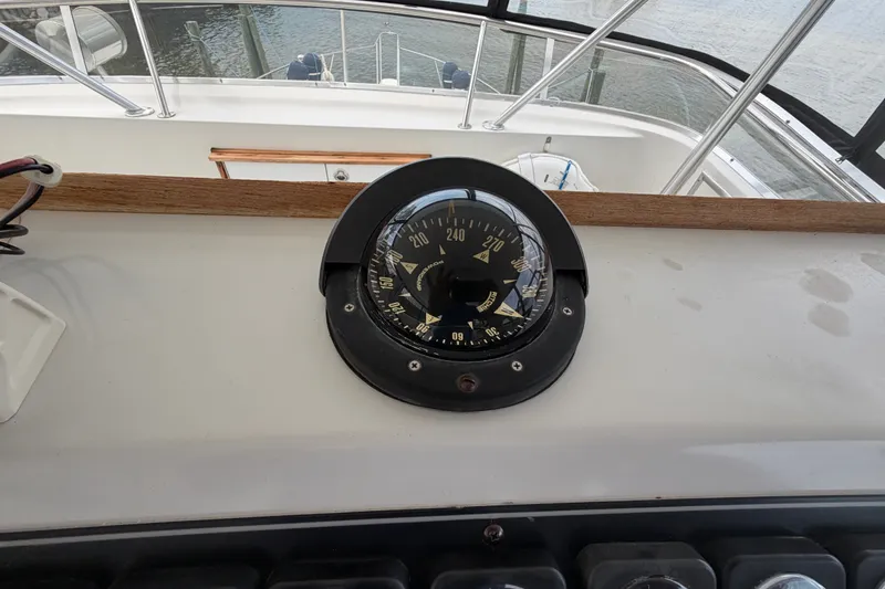 Slide: The Image of Compass on 1989 Chris-Craft 427 Catalina yacht dashboard, overlooking water. - 22