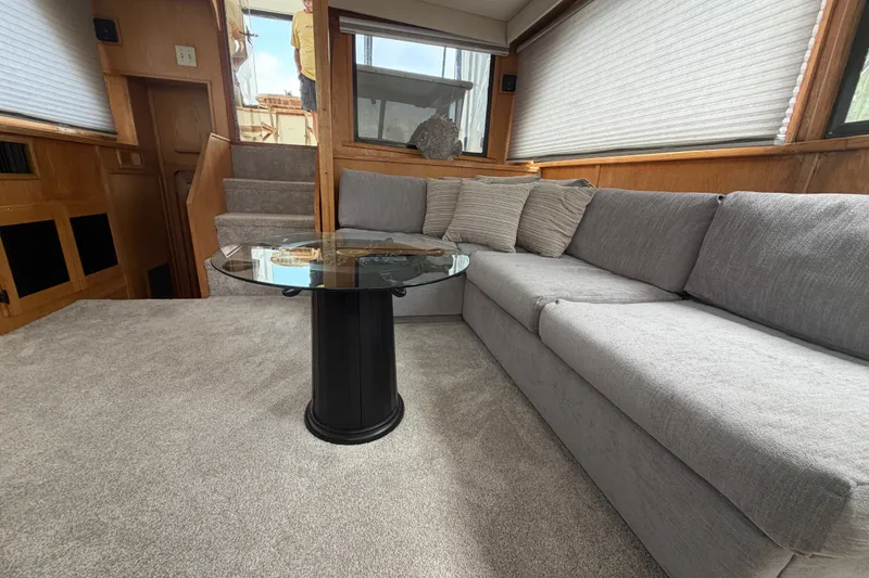 Slide: The Image of Luxurious interior of 1989 Chris-Craft 427 Catalina yacht with plush gray seating and glass table. - 32