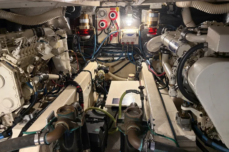 Slide: The Image of Engine room of a 1989 Chris-Craft 427 Catalina, showcasing mechanical components and wiring. - 49
