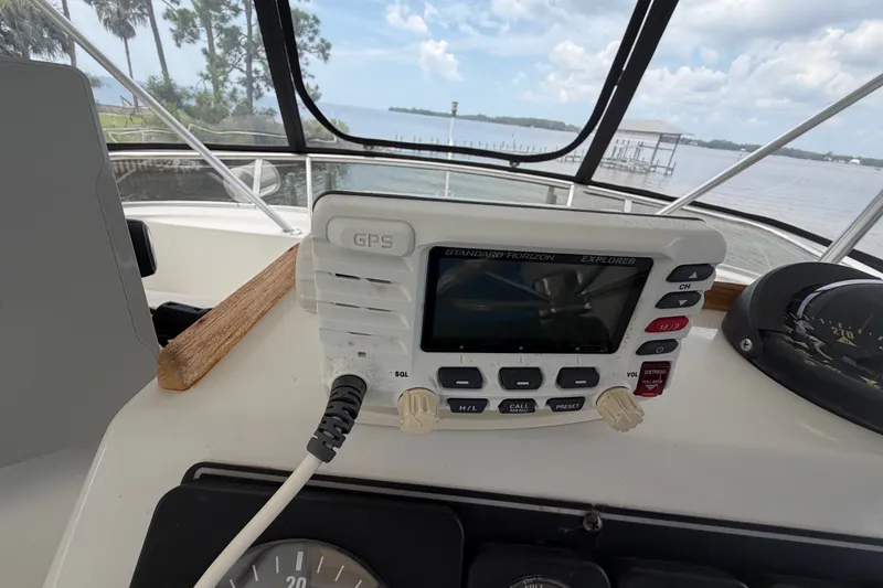 Slide: The Image of 1989 Chris-Craft 427 Catalina helm with GPS and navigation instruments, overlooking serene waters. - 17