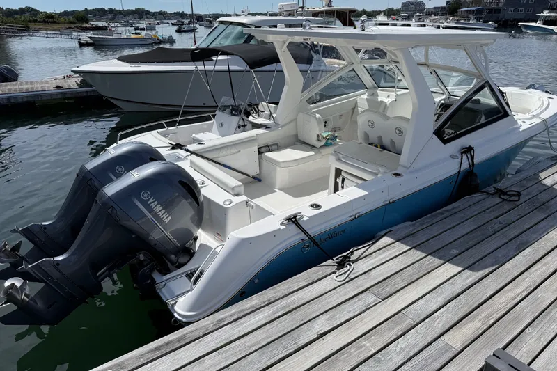 Slide: The Image of 2023 Edgewater 262CX Crossover boat docked with twin Yamaha engines. - 2