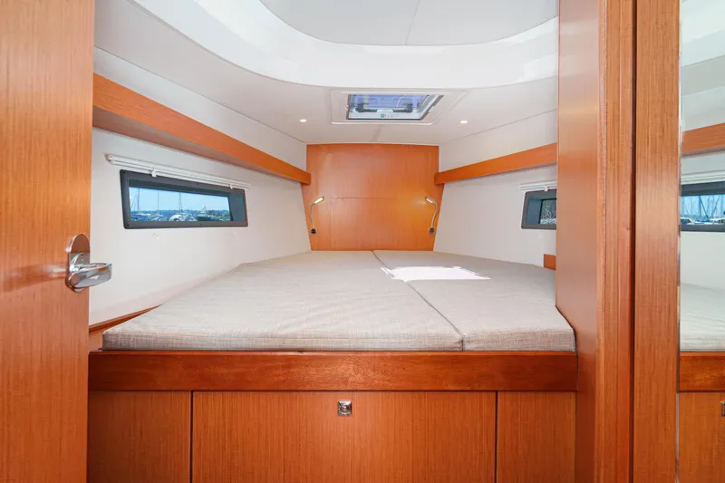 Slide: The Image of 2023 Bavaria C42 yacht cabin interior with wooden finish and large bed. - 44