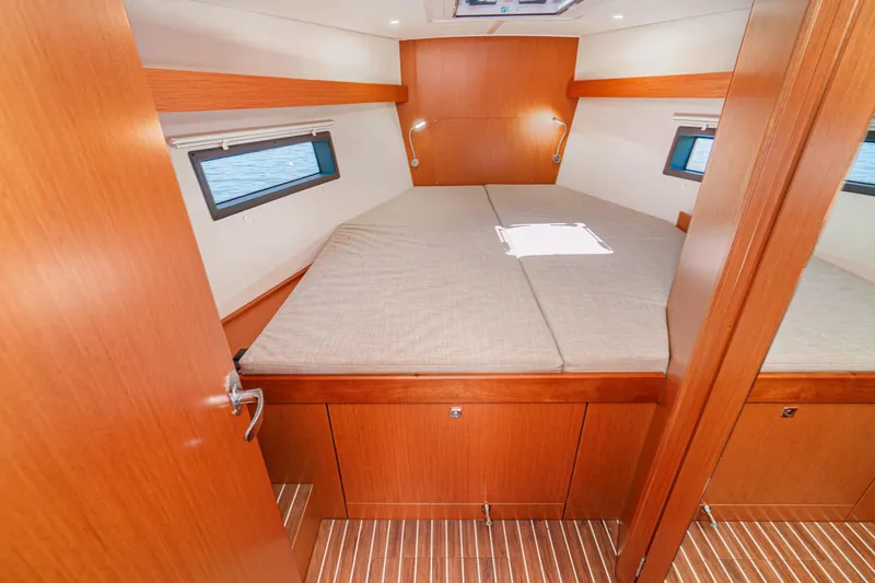 Slide: The Image of 2023 Bavaria C42 yacht cabin interior with wooden finish and cozy bed. - 43