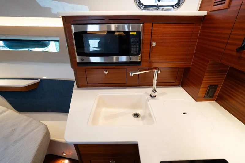 Slide: The Image of Modern galley kitchen in 2025 Pursuit OS 405 Offshore boat with microwave and sink. - 55