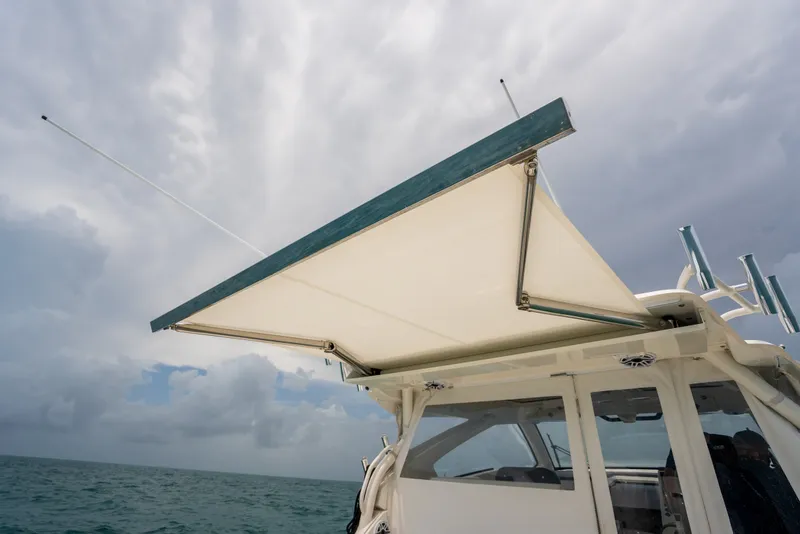 Slide: The Image of 2025 Pursuit OS 405 Offshore boat with extended canopy on open sea. - 48
