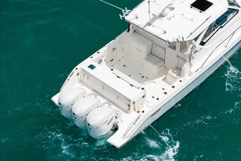 Slide: The Image of 2025 Pursuit OS 405 Offshore boat with triple outboard engines on turquoise water. - 5