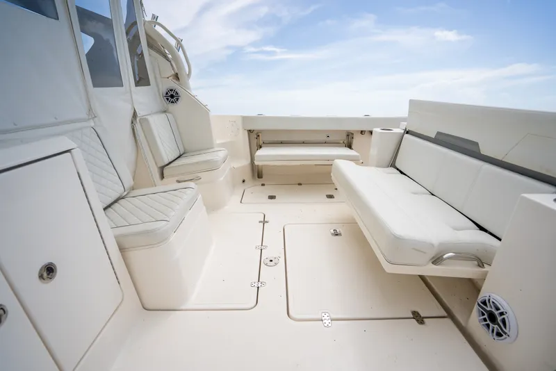 Slide: The Image of 2025 Pursuit OS 405 Offshore boat interior with white seating and storage compartments. - 35
