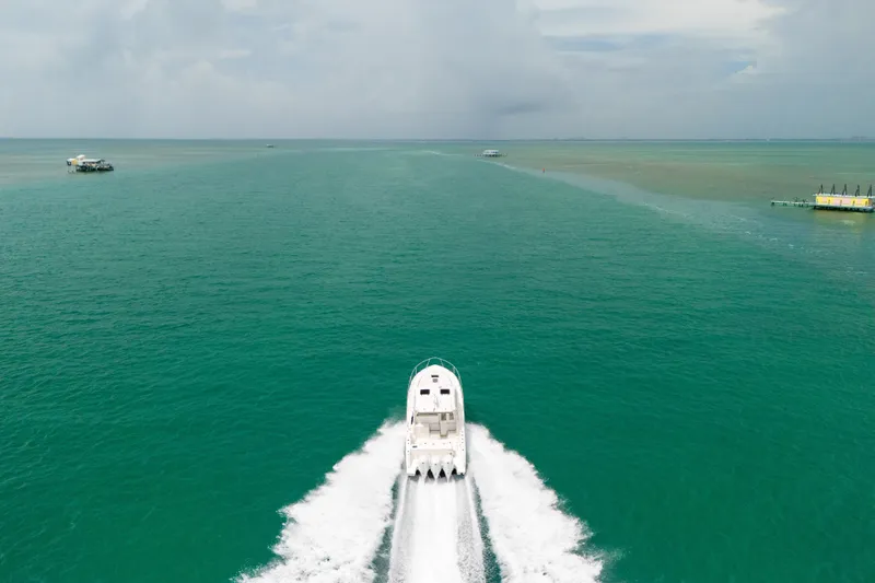 Slide: The Image of 2025 Pursuit OS 405 Offshore boat cruising on open turquoise waters. - 17