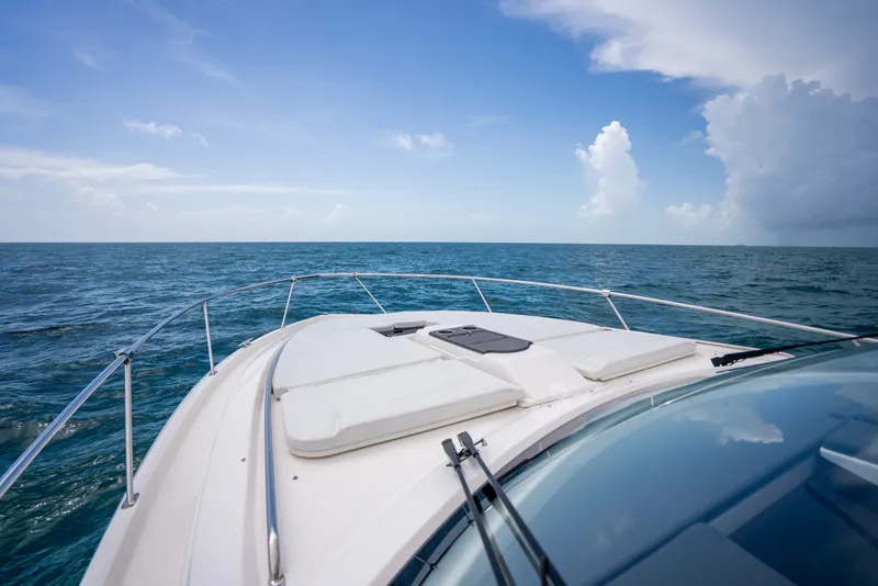 Slide: The Image of 2025 Pursuit OS 405 Offshore boat cruising on open ocean under clear blue sky. - 50