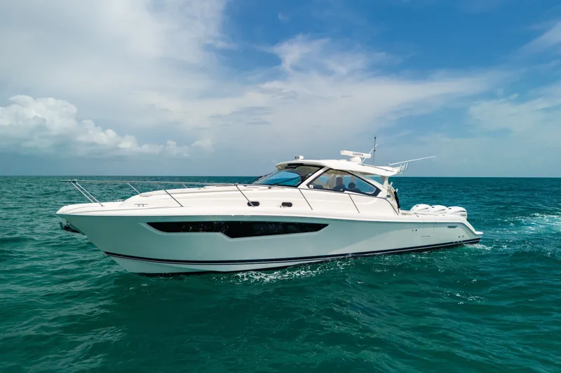Slide: The Image of 2025 Pursuit OS 405 Offshore yacht cruising on open sea under clear blue sky. - 1