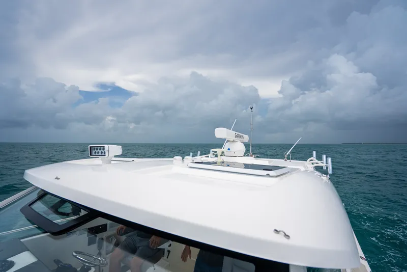 Slide: The Image of 2025 Pursuit OS 405 Offshore boat navigating under cloudy skies. - 21