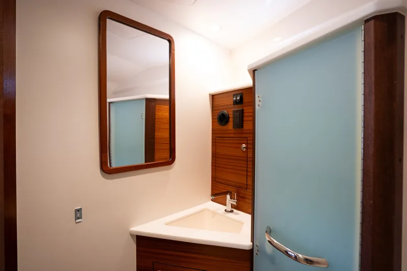 Slide: The Image of 2025 Pursuit OS 405 Offshore yacht bathroom with modern sink and mirror. - 62
