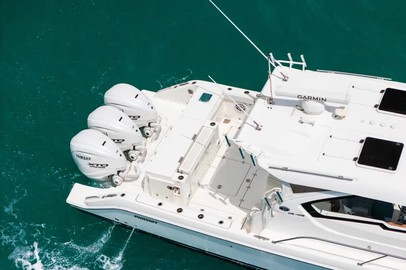 Slide: The Image of 2025 Pursuit OS 405 Offshore boat with triple Yamaha engines on turquoise water. - 4