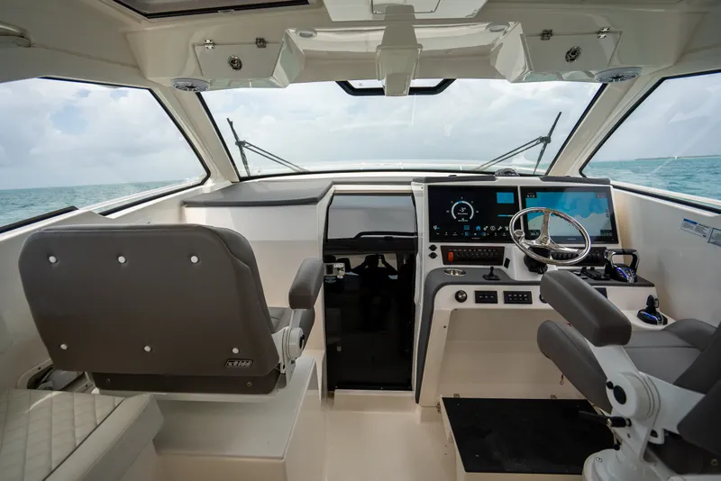 Slide: The Image of 2025 Pursuit OS 405 Offshore boat cockpit with modern navigation equipment and steering wheel. - 47