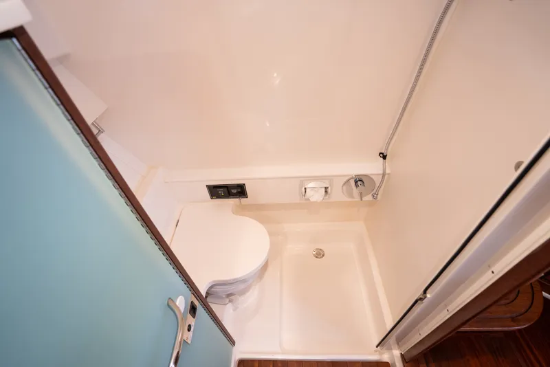Slide: The Image of 2025 Pursuit OS 405 Offshore bathroom with shower and toilet, compact marine design. - 64