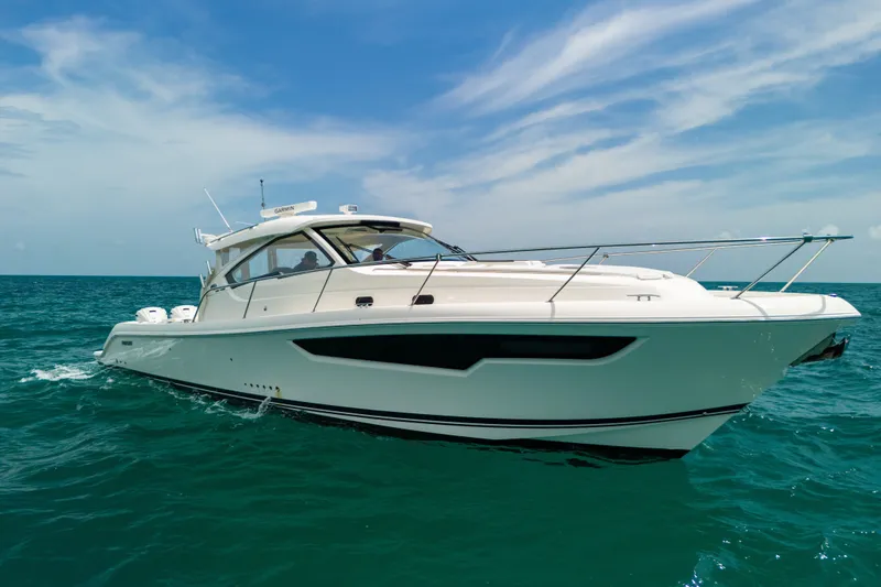 Slide: The Image of 2025 Pursuit OS 405 Offshore yacht cruising on open sea under clear blue sky. - 0