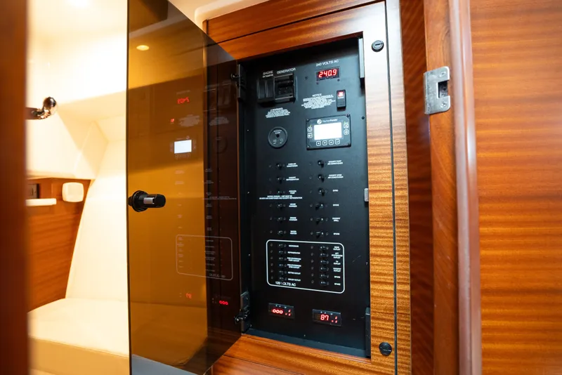 Slide: The Image of Electrical panel inside 2025 Pursuit OS 405 Offshore boat, featuring modern controls and wood finish. - 71
