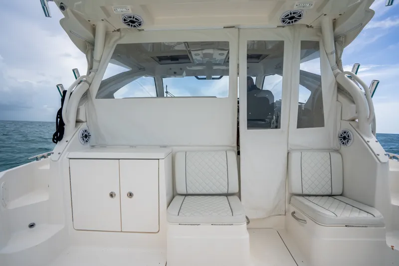 Slide: The Image of 2025 Pursuit OS 405 Offshore boat interior with cushioned seating and ocean view. - 24
