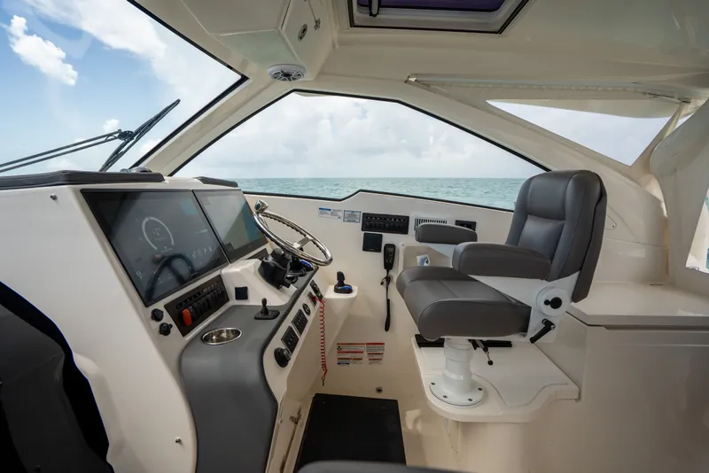 Slide: The Image of Interior of 2025 Pursuit OS 405 Offshore boat, featuring modern helm and seating. - 38