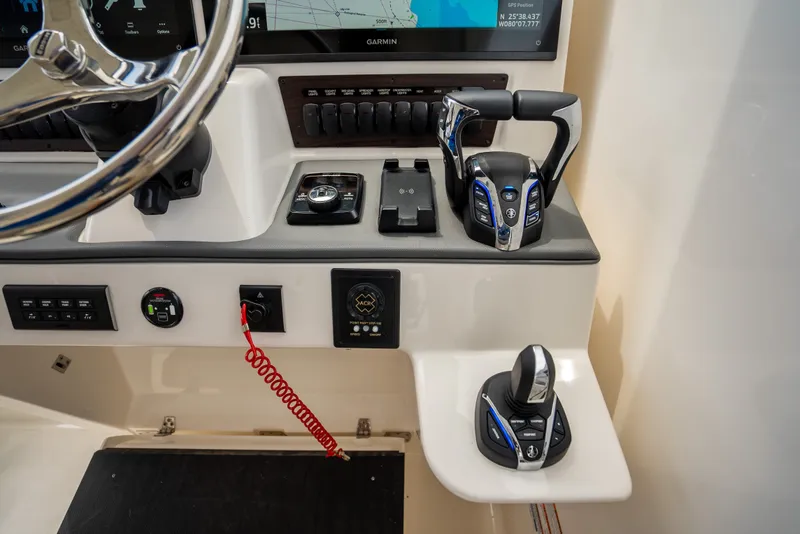 Slide: The Image of Control panel of 2025 Pursuit OS 405 Offshore boat with advanced navigation and throttle systems. - 44