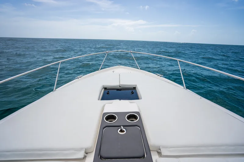 Slide: The Image of Bow view of 2025 Pursuit OS 405 Offshore boat cruising on open sea. - 20