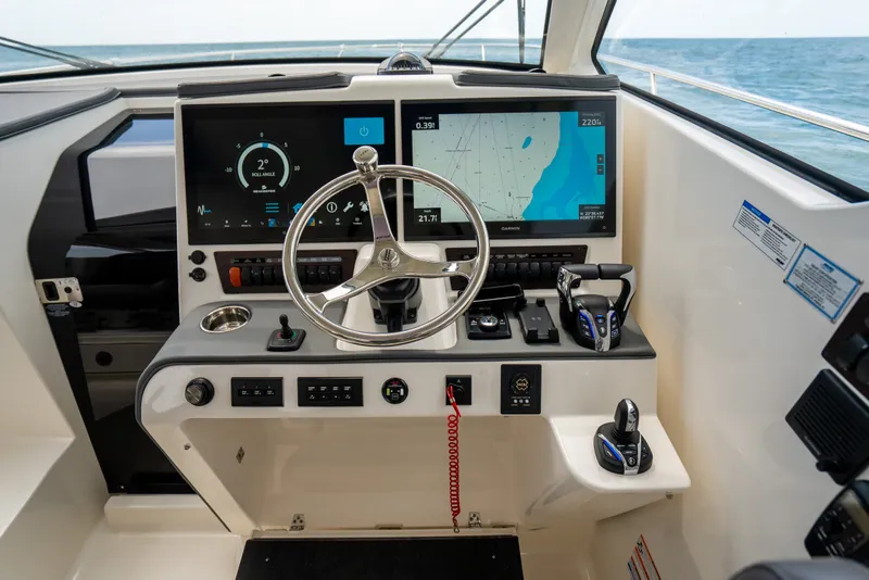 Slide: The Image of Helm of 2025 Pursuit OS 405 Offshore boat with advanced navigation displays and controls. - 39