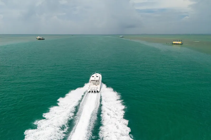 Slide: The Image of 2025 Pursuit OS 405 Offshore boat cruising on open turquoise waters. - 16