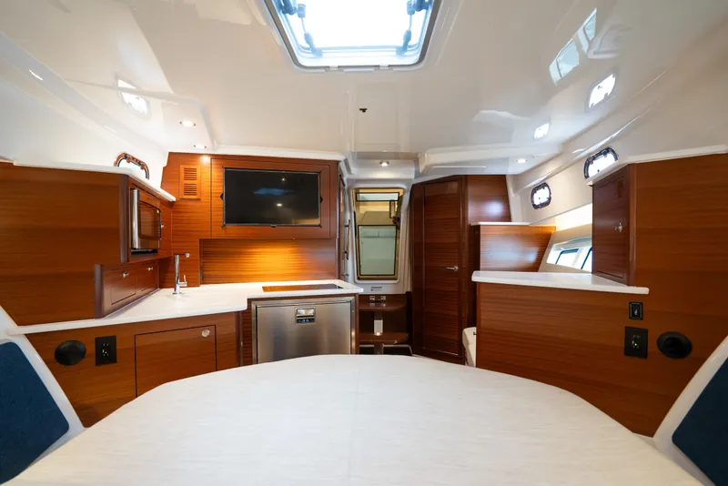 Slide: The Image of Luxurious interior of 2025 Pursuit OS 405 Offshore boat with modern amenities and wood finishes. - 58