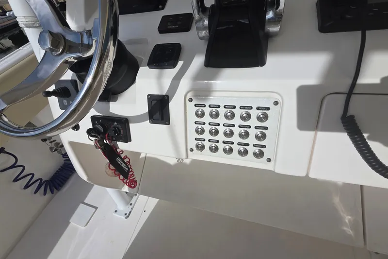 Slide: The Image of Control panel of a 2015 Intrepid 327 Center Console boat with steering wheel and switches. - 32