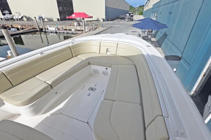 Slide: The Image of 2015 Intrepid 327 Center Console boat with spacious seating at a marina. - 6