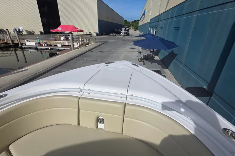 Slide: The Image of Bow view of 2015 Intrepid 327 Center Console docked near industrial buildings. - 12