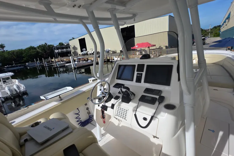 Slide: The Image of 2015 Intrepid 327 Center Console boat interior with advanced navigation systems at a marina. - 33