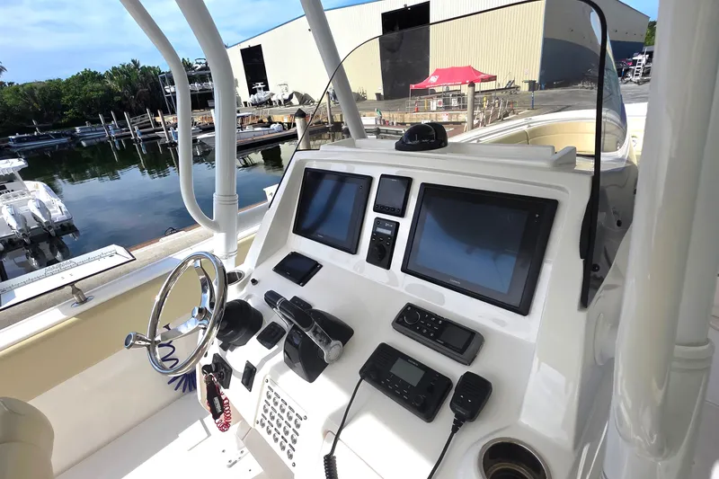 Slide: The Image of 2015 Intrepid 327 Center Console boat dashboard with navigation screens and controls. - 31