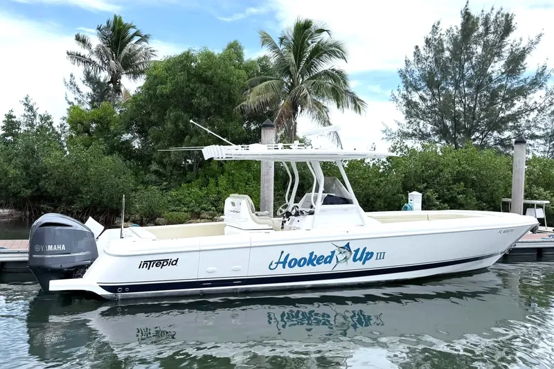 The Image of 2015 Intrepid 327 Center Console boat docked, featuring Yamaha engines and "Hooked Up III" branding. - 0