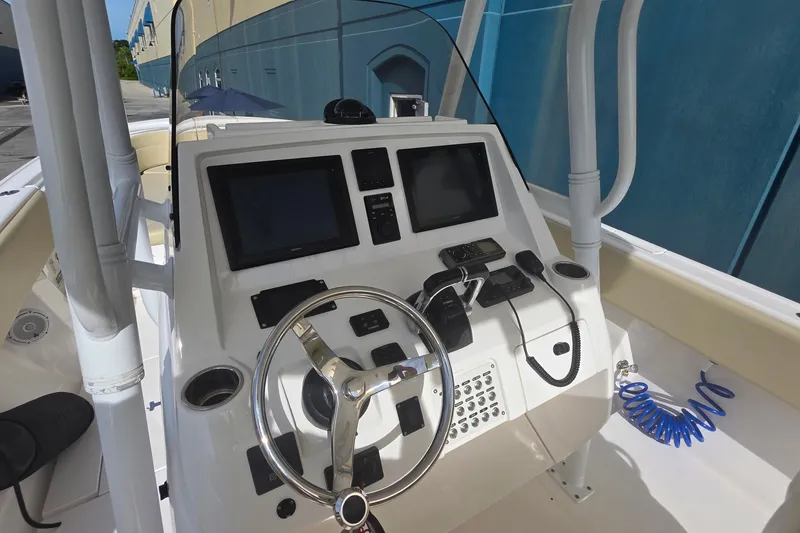 Slide: The Image of 2015 Intrepid 327 Center Console boat dashboard with steering wheel and navigation controls. - 24