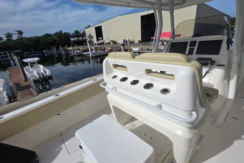 Slide: The Image of 2015 Intrepid 327 Center Console boat docked at marina, featuring helm and seating area. - 30
