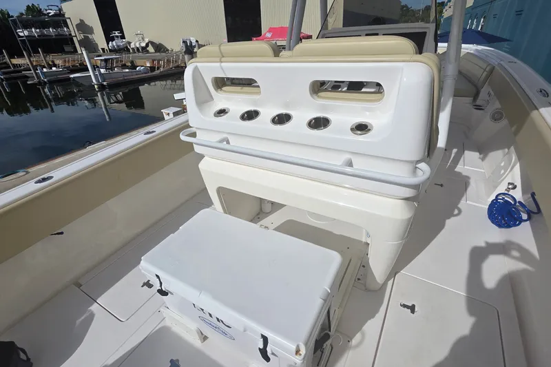 Slide: The Image of 2015 Intrepid 327 Center Console boat interior with seating and storage at a marina. - 26