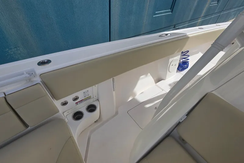 Slide: The Image of 2015 Intrepid 327 Center Console boat interior with beige seating and cup holders. - 21