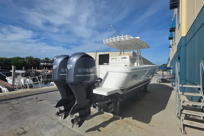 Slide: The Image of 2015 Intrepid 327 Center Console boat with twin Yamaha engines docked outdoors. - 3